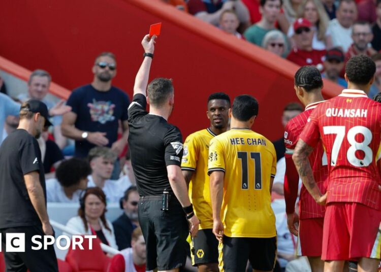 Nelson Semedo is show a red card as Liverpool and Wolves players surround him