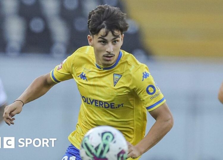 Rodrigo Gomes runs with the ball wearing Estoril's yellow shirt