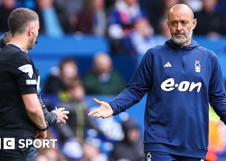 Nuno Espirito Santo, wearing a blue Nottingham Forest tracksuit, gestures to a match official