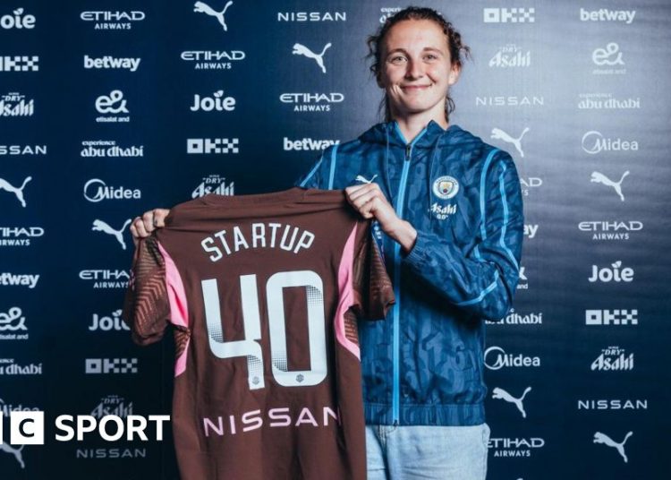 Katie Startup holds up a Manchester City shirt